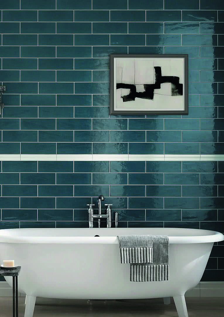 Bathroom finished with deep teal wall tiles and a freestanding bath