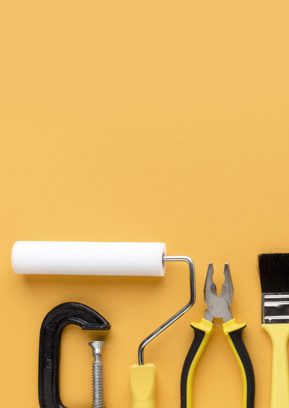 Hand tools laid out on an orange surface
